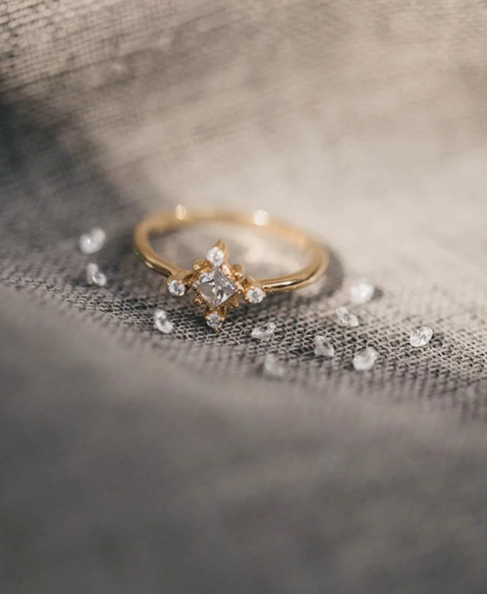 anillo de oro con brillantes blancos sobre tela
